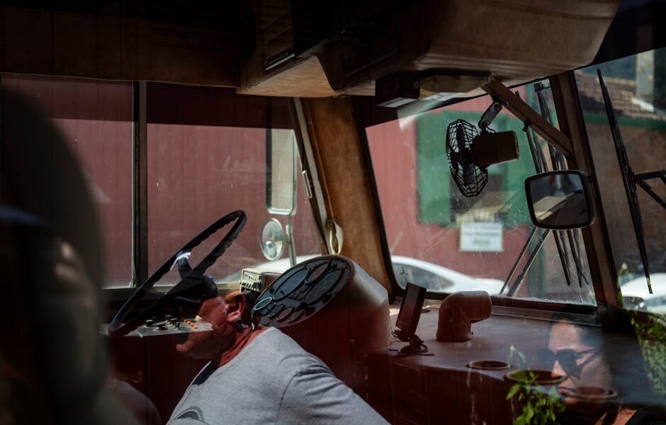 Een buschauffeur in uniform die een bus bestuurt, klaar om passagiers veilig naar hun bestemming te brengen.